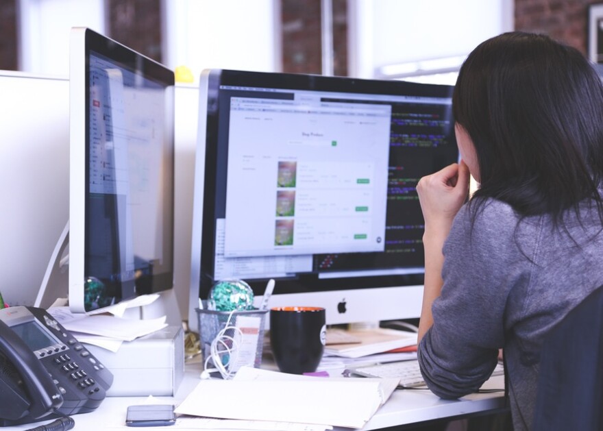 woman working at computer screens.