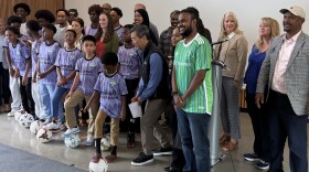 Seattle Mayor Katie Wilson poses with adults and kids kicking a soccer ball.