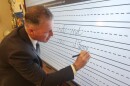 State Rep. Dane Watro signs his name on the board in Diane Mussoline’s classroom at Valley Elementary/Middle School.