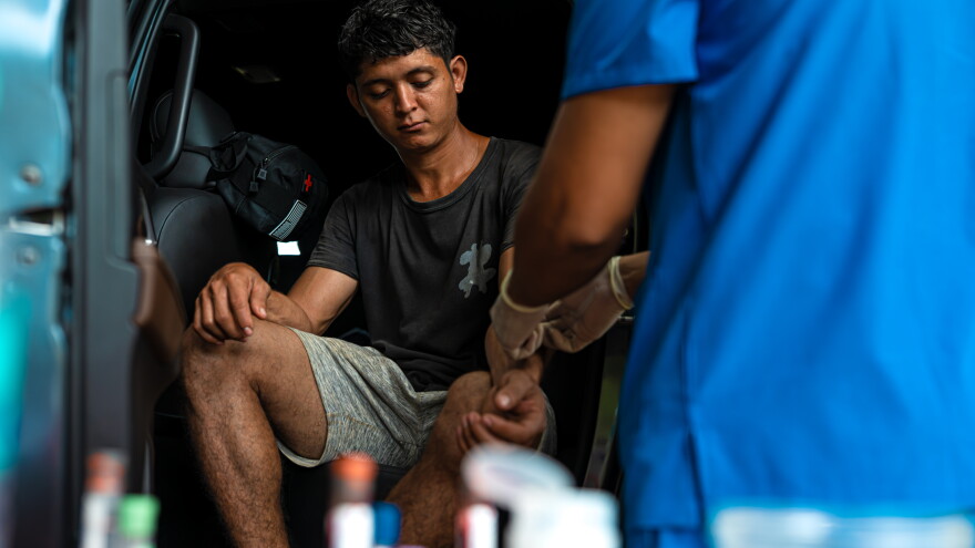 A participant watches as a nurse prepares to draw blood for the CURE study in Usulutan, El Salvador.