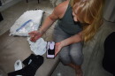 Cox shows on her phone the features of the bra she and Amanda Hunt designed. The bra is black, of soft material, has adjustable straps, and three layers of hook and eye closures in the front for adjustable compression levels. The surgical recovery bra market is valued at $1.8 billion annually, and is expected to nearly double in the next eight years.