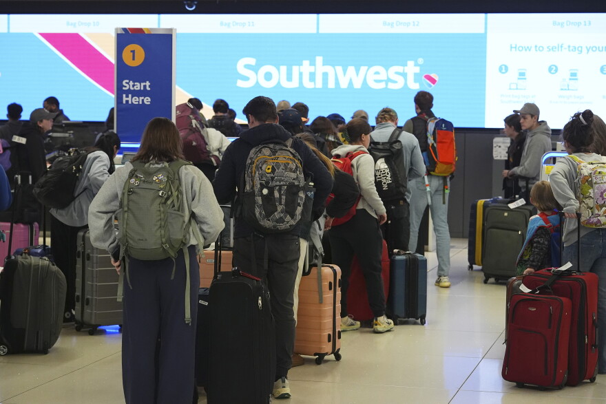 FILE - Travelers wait at the check-in counter for Southwest Airlines in Denver International Airport Thursday, Dec. 19, 2024, in Denver. (AP Photo/David Zalubowski, File)