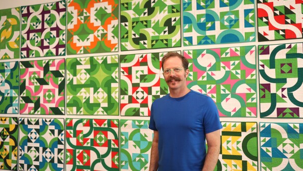 Artist Ben Millett poses for a portrait in front of "If I Had Said Yes," a multi-piece artwork made up of 21 individual quilts created specifically for the exhibition.