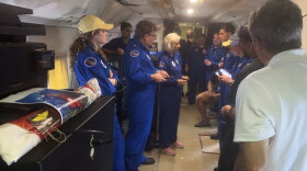 In this image released by the National Oceanic and Atmospheric Administration, a NOAA crew on a reconnaissance flight, Tuesday, Oct. 8, 2024, into the eye of Hurricane Milton in the Gulf of Mexico, gather before dropping a package containing the ashes of Peter Dodge, an award-winning scientist who made almost 400 hundreds flight into the eyes of hurricanes, as a lasting tribute to the longtime radar specialist and researcher.