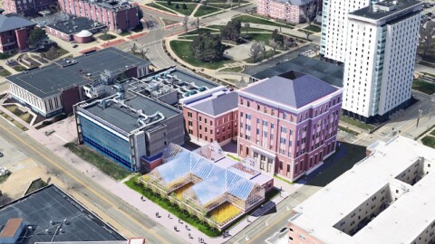 An aerial view of three buildings and a glass greenhouse