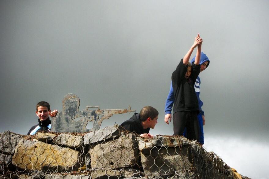Israeli boys play by metal cutouts of soldiers on the top of Mount Bental, on the Israeli-occupied side of the frontier with Syria.