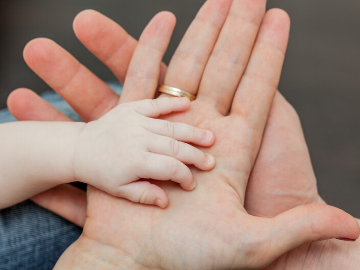 A mother holding a child's hand.