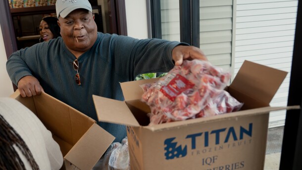 Craig Brown, an Urban League Food Pantry volunteer from Normandy, reaches for a bag of frozen strawberries to place in residents’ food boxes on Tuesday, Oct. 28, 2025, at the organization’s headquarters in St. Louis’ Fountain Park neighborhood.