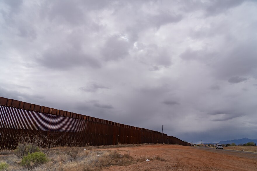 The border wall extends as far as the eye can see from downtown Naco, Ariz.