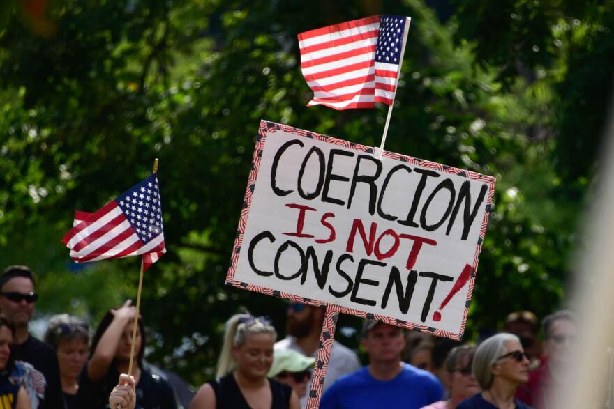 A demonstrator holds a sign at a rally outside the Indiana Statehouse in September opposing any COVID-19 vaccine requirements.