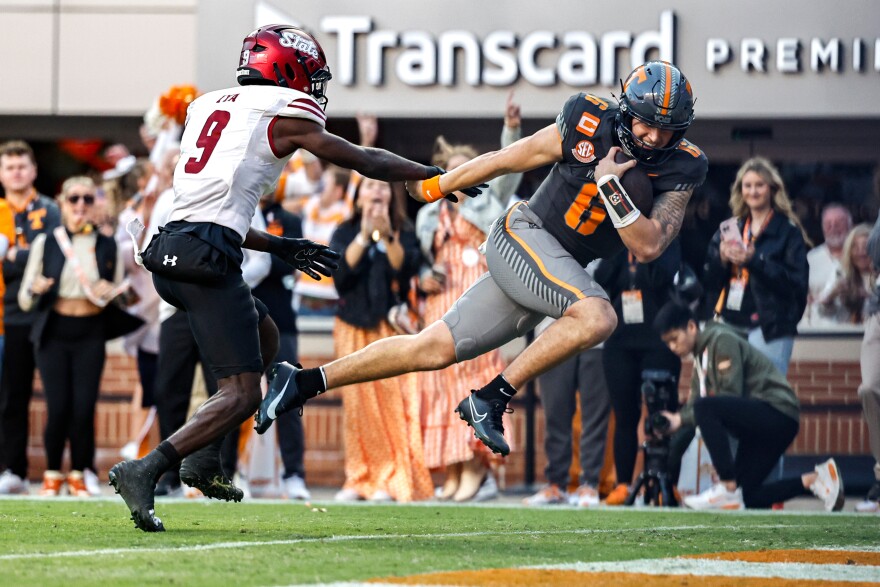 Tennessee quarterback Joey Aguilar (6) runs for a touchdown in front of New Mexico State safety Bernock Iya (9) during the first half of an NCAA college football game Saturday, Nov. 15, 2025, in Knoxville, Tenn. (AP Photo/Wade Payne)