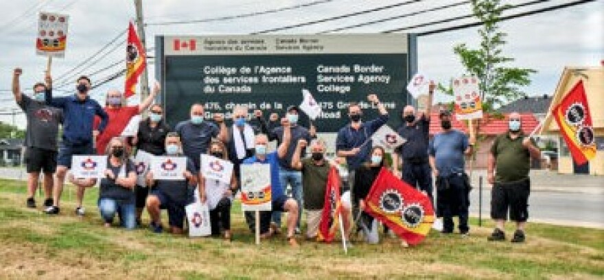 A group of Canadian border control union members holding signs and flags