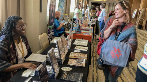 Garicka Hill, left, co-founder of PLPG Publishing, talks with Sammy Herzberg, director of the Oskaloosa Public Library during the Kansas Library Association's annual conference in Wichita.