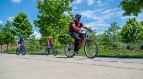 A family wears masks while biking near Smale Park in May. The Cleveland Clinic's Aaron Hamilton says he will wear his mask during outdoor activities where he cannot safely socially distance from other people. 
