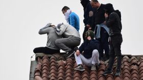 Inmates stage a protest on a rooftop of a wing at the San Vittore prison in Milan in one of Italy's quarantine red zones. Inmates in four Italian prisons have revolted over new rules introduced to contain the coronavirus outbreak.