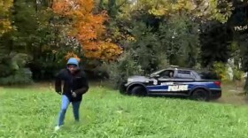 A screenshot from a video posted to social media shows a now-suspended Baltimore Police officer in a cruiser chasing a man who is running away on foot.