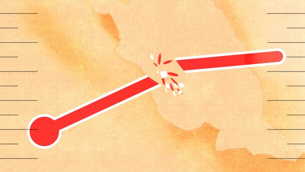 A broken thermometer in front of a orange background with burned edges