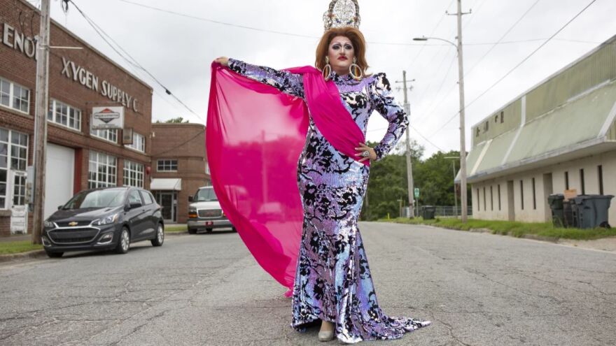 Drag queen Michelle Michaels stands in the street outside of The Herritage Tap Room and Bottle Shop in Kinston, N.C., in June 2021, before hosting a drag brunch event. (Image: Madeline Gray / WUNC)