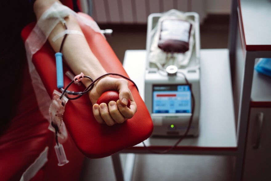 A man gives blood in a blood donation center.