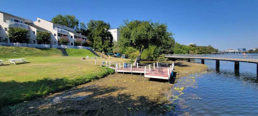 A dock out onto a lake is seen without water under the majority of it as lake levels receded. 