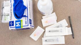 Syringes, gloves and sanitizer are seen on a table where nurses are administering COVID-19 vaccines.