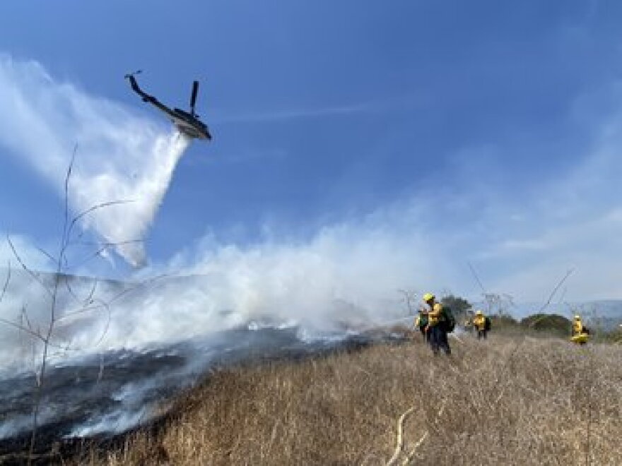 A helicopter makes a water drop on the Anne brush fire northwest of Goleta Thursday afternoon.