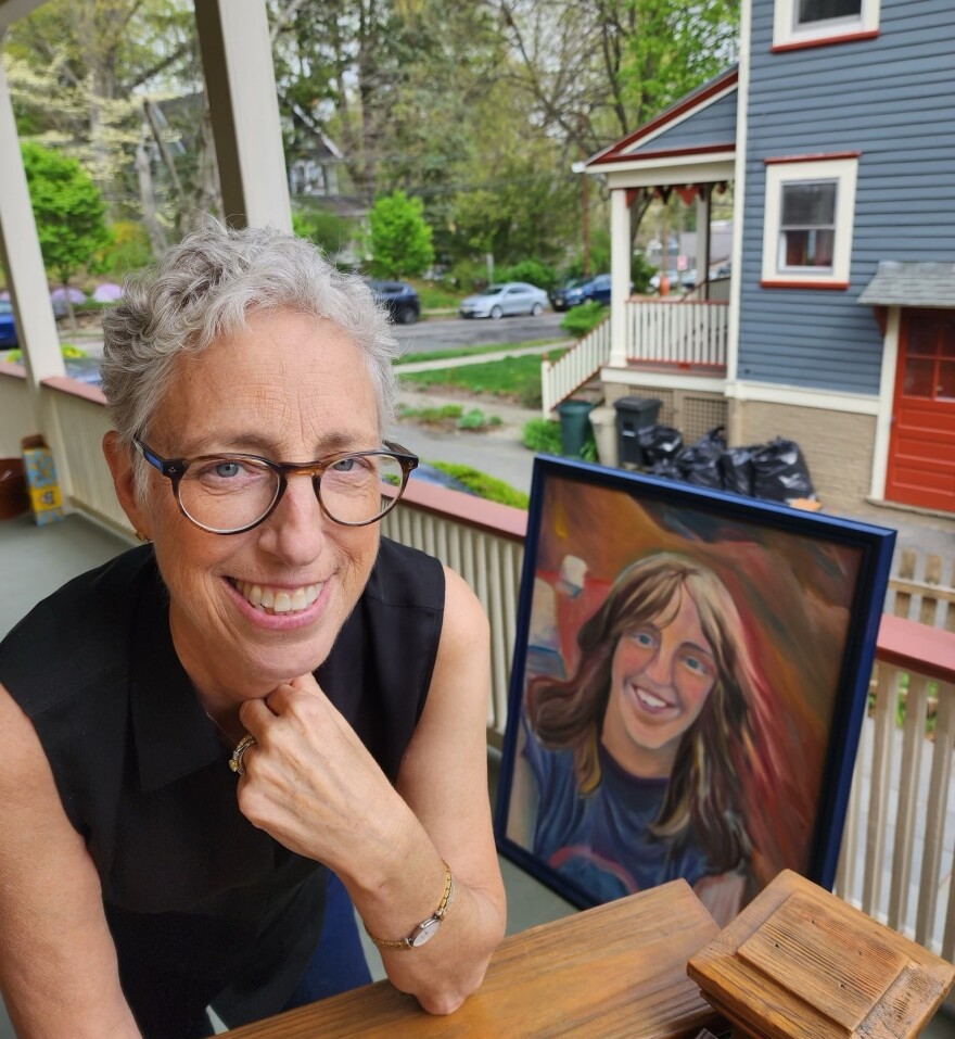 Julie Petrow-Cohen at her 61st birthday, with a painting done by her brother Jay when she was 16.