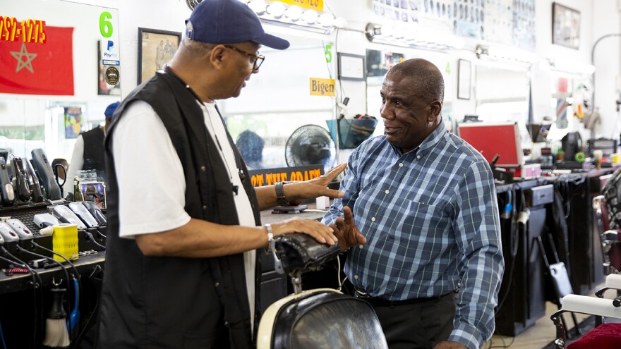 Sen. Lionell Spruill Sr. talks with barber Wallace Sivillis at The Den Barber Shop in Chesapeake, Va., on Tuesday, May 23, 2023. 