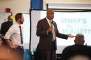 Two men stand speak in front of a group gathered at a community center in Cleveland, Ohio.