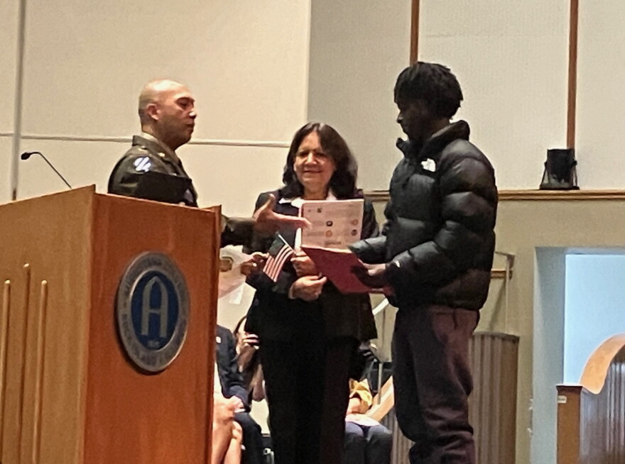 Rock Island Arsenal Command Sgt. Maj. Michael Asuncion greets two of the new U.S. citizens during Tuesday's ceremony at Centennial Halll, Rock Island.