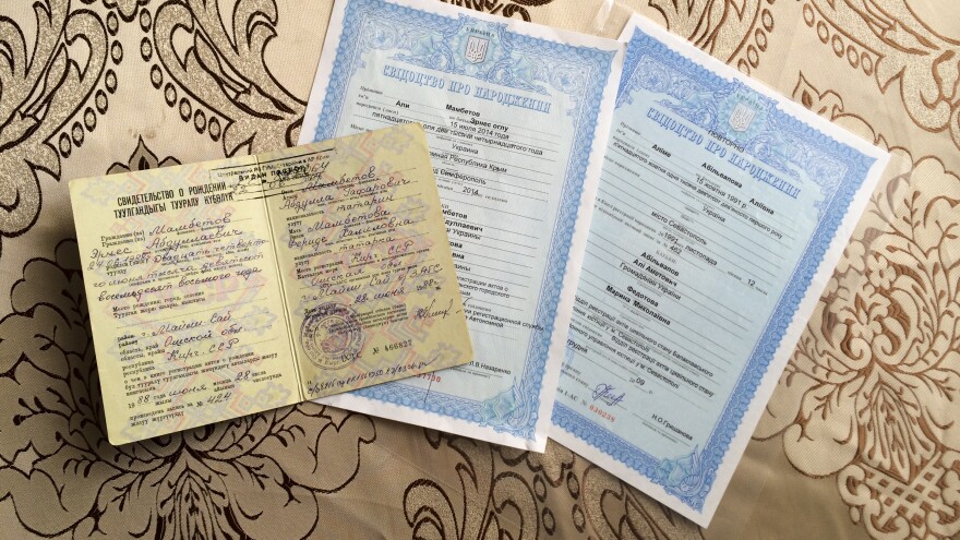The top document is Ernes Ayserezli's Soviet birth certificate. His wife, born after the Soviet Union collapsed, has a Ukrainian one – the very same Ukrainian document that the couple wanted so badly for their infant son, Ali. They made it just in time, before the hospital began printing Russian ones.