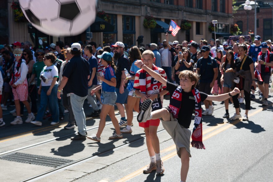 A child rooting for the U.S. men's soccer team kicks an inflatable soccer ball.