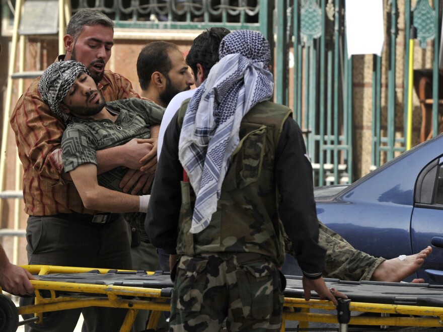 Syrians lift a wounded rebel fighter to take him into a hospital in Aleppo, Syria, in October. Doctors have few supplies to treat wounded fighters in Syria.