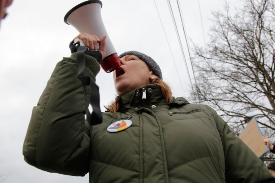 Leslie Brown, an activist with Edmonds Neighborhood Action Coalition, shouted into a bullhorn to rally dozens of protesters gathered outside the Edmonds PCC, January 29, 2017. 