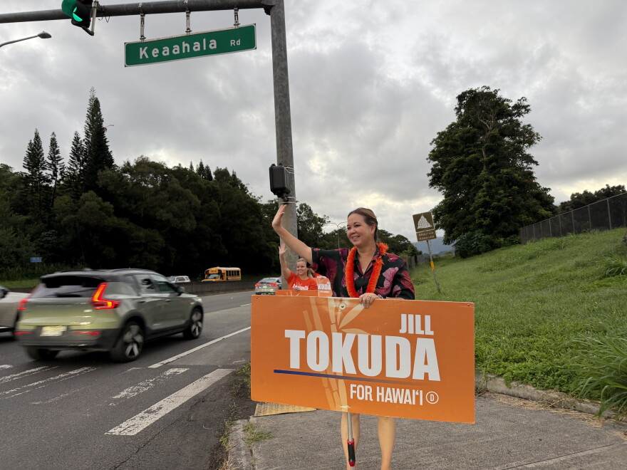 U.S. Rep. Jill Tokuda waves at morning commuters in Kāneʻohe, Hawaii on Monday, Oct. 26, 2026.