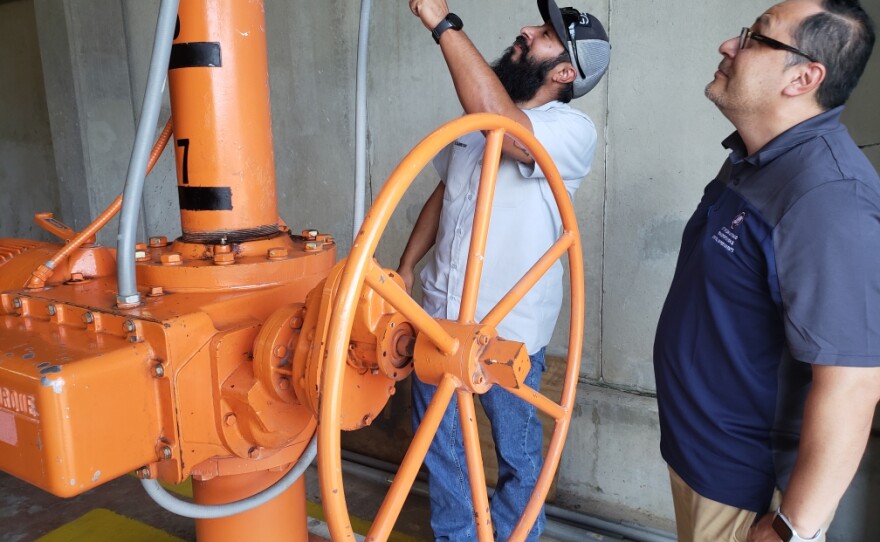 Nefi Garza, on right, assistant director of San Antonio's Transportation & Capital Improvements Department, and department worker Dave Carreon inspects the control room at Olmos Dam on 10/10/18