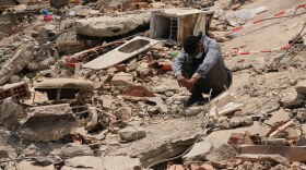 FILE - A man sits amid earthquake rubble in La Guaira, Venezuela, June 29, 2026.