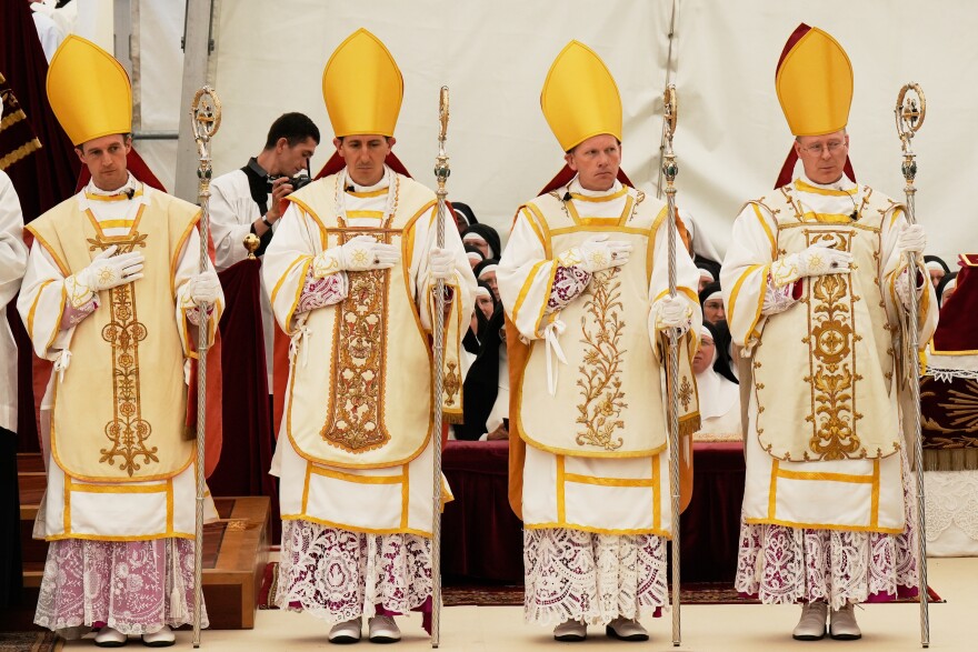 Newly consecrated bishops, from left, Marc Hanappier, Michel Poinsinet de Sivry, Michael Goldade and Pascal Schreiber wearing their miters and holding their pastoral staffs, stand at the end of their consecration ceremony in a tent set up outside the Society of St. Pius X seminary in Econe, Switzerland, Wednesday, July 1, 2026.