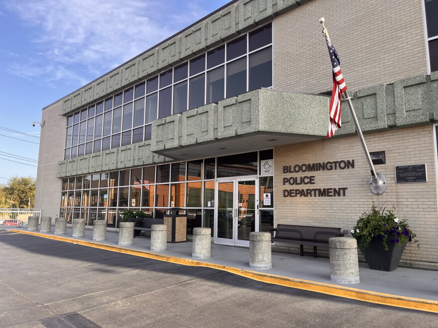 an American flag hangs next to the Bloomington Police Department entrance 