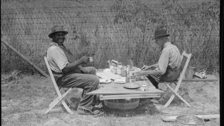 A stable hand and a trainer eat a picnic lunch before the Shelby County Horse Show and Fair, Shelbyville, Ky.