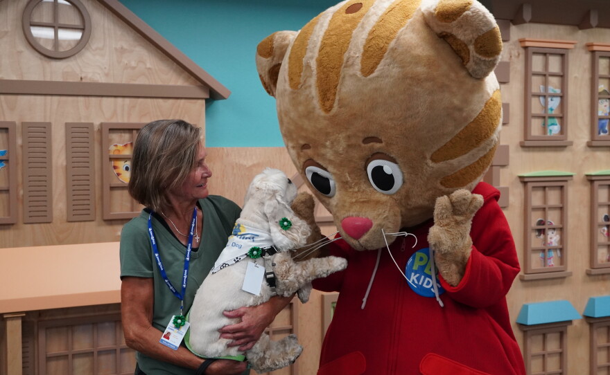 Daniel Tiger walk around character greets a dog