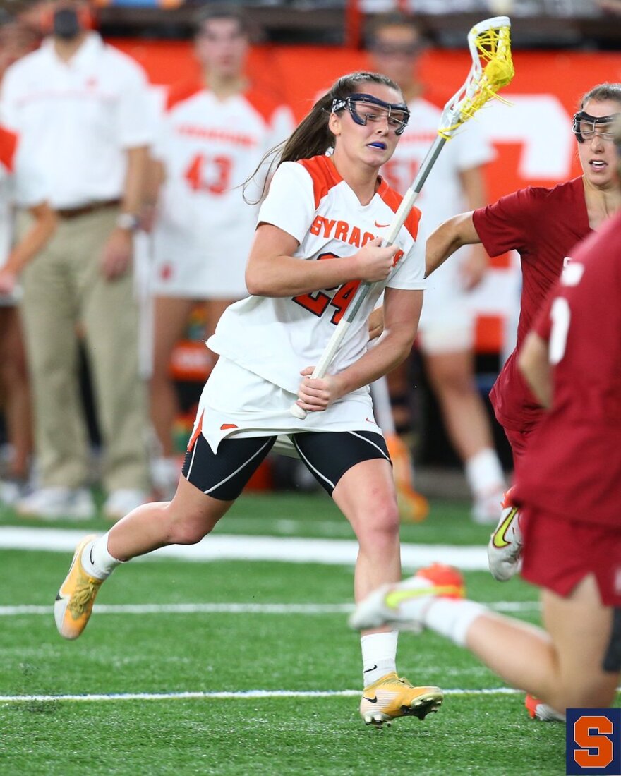 Emma Tyrrell (White #24) dodges towards cage as part of Syracuse's opening night win over Stanford. 