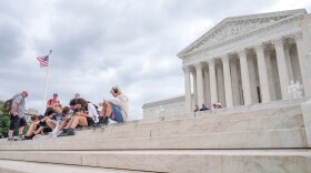 Visitors sit on the steps of the U.S. Supreme Court, Monday, June 8, 2026, in Washington. (AP Photo/Mariam Zuhaib)