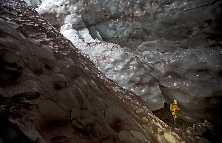 Mapping another world: An explorer writes down survey data in a glacier cave on Mount Hood.