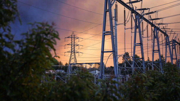 Smoke from the Eaton Fire fills the sky behind electrical infrastructure in La Cañada Flintridge on Jan. 8, 2025.