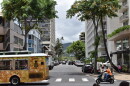 A bus and motorcycle drive down a street in Waikīkī on Oʻahu on July 21, 2026.