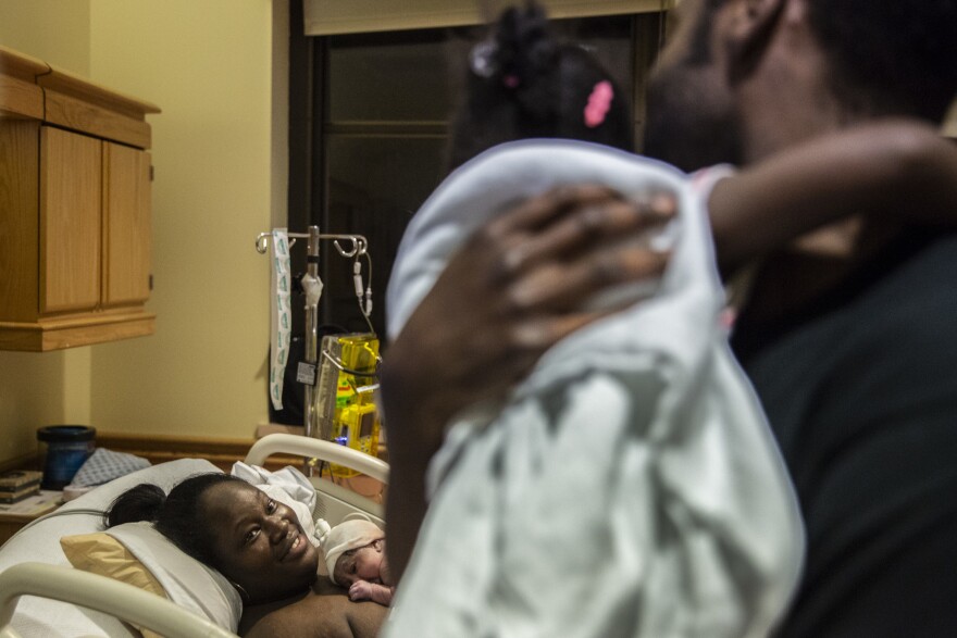 Anthony Williams and his daughter, Ariya, check on her mother, Tanisha Williams, after she delivered her and Anthony's newborn son, Mason.