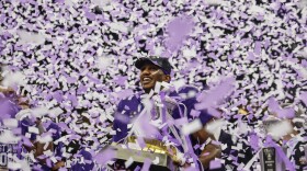 Michael Penix Jr. celebrating with a trophy as confetti flies around him