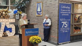 Sister Eileen O'Connor of the Sisters of Mercy, stands at a lectern leading a prayer at Kenmore Mercy Hospital.