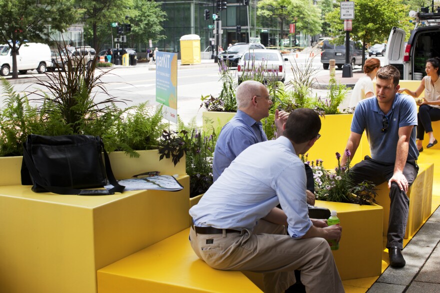 Will Handsfield (right), transportation director for the Georgetown Business Improvement District, talks with other parklet visitors in Washington, D.C. The Georgetown neighborhood hopes to have a parklet by September, and other areas may follow suit.